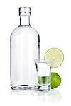 Bottle of vodka and shot glass with lime slice. Isolated on white background