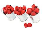 Three Tin Buckets with Perfect Ripe Raspberries In a Row isolated on white background