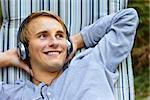 Young good looking male relaxing and listening to music with headphones.