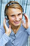 Young male listening to music via headphones