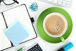 Green coffee cup and office supplies. View from above. Closeup