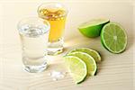 Blanc and Gold Tequila with lime and salt on wood table isolated on white background