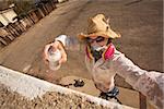 Graffiti artist in hat and sunglasses spray painting