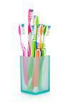 Multicolored toothbrushes in glass. Isolated on white background