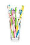 Colorful toothbrushes in glass. Isolated on white background