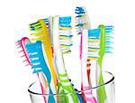Colorful toothbrushes in glass. Closeup. Isolated on white background