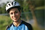 portrait of young woman training on mountain bike and smiling at camera. Defocused image