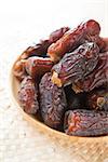 Dates fruit. Pile of fresh dried date fruits in a wooden plate.