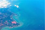 Aerial view of the shore covered by fields areas with blue sea