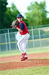 Little league baseball boy pitching during a game.