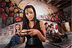 Serious African young woman holding cell phone