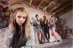 Unhappy blond girl near cruel group of teens