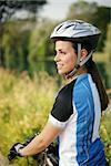 portrait of young woman training on mountain bike and smiling and looking at view