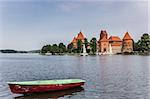 Trakai castle and a red and green boat in lake Galve