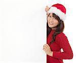 Christmas young girl showing blank billboard banner sign smiling happy looking at camera. Beautiful and cute Asian female model