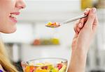 Closeup on happy young woman eating fruits salad