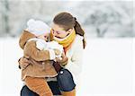 Mother and baby playing in winter park