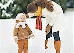 Mother and baby playing in winter outdoors