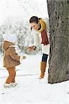 Happy mother playing with baby in winter outdoors