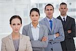 Serious business people posing crossing arms in bright office