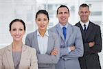 Smiling business people posing crossing arms in bright office