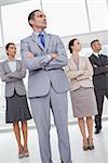 Unsmiling work team in bright office posing while looking in the same direction