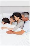 Beautiful family sleeping together in bed at home