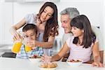 Family eating breakfast in kitchen together at home