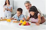 Cute family eating breakfast in kitchen together at home