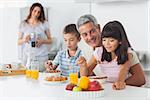 Happy family eating breakfast in kitchen together at home