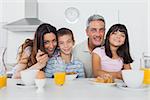 Beautiful family eating breakfast in kitchen together at home