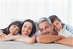 Beautiful family in sitting room smiling at camera at home