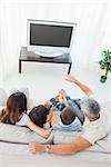 Family with popcorn watching their television on sofa in the sitting room