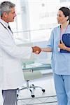 Doctor shaking hands with nurse in medical office