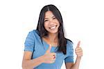 Smiling asian woman giving thumbs up at camera on white background