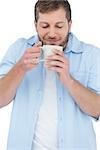 Casual model on white background having coffee and smelling it