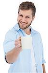 Smiling model on white background offering a mug