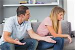 Couple sitting on the couch having an argument in sitting room at home