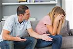 Couple sitting on the couch having a fight in sitting room at home