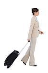 Serious businesswoman pulling suitcase against white background
