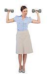 Strong businesswoman posing with dumbbells looking at camera against white background