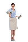 Tough businesswoman lifting dumbbells looking at camera against white background