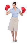 Attractive businesswoman posing with boxing gloves against white background