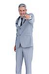 Confident businessman posing against white background and pointing at camera