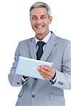 Happy businessman using tablet pc looking at camera on white background