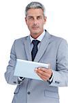Serious businessman using digital tablet on white background
