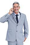 Happy businessman answering phone against white background