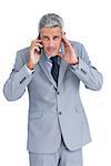 Concentrated businessman answering phone against white background
