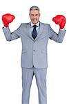 Businessman posing with red boxing gloves on white background