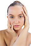 Pretty young model posing touching her face on white background